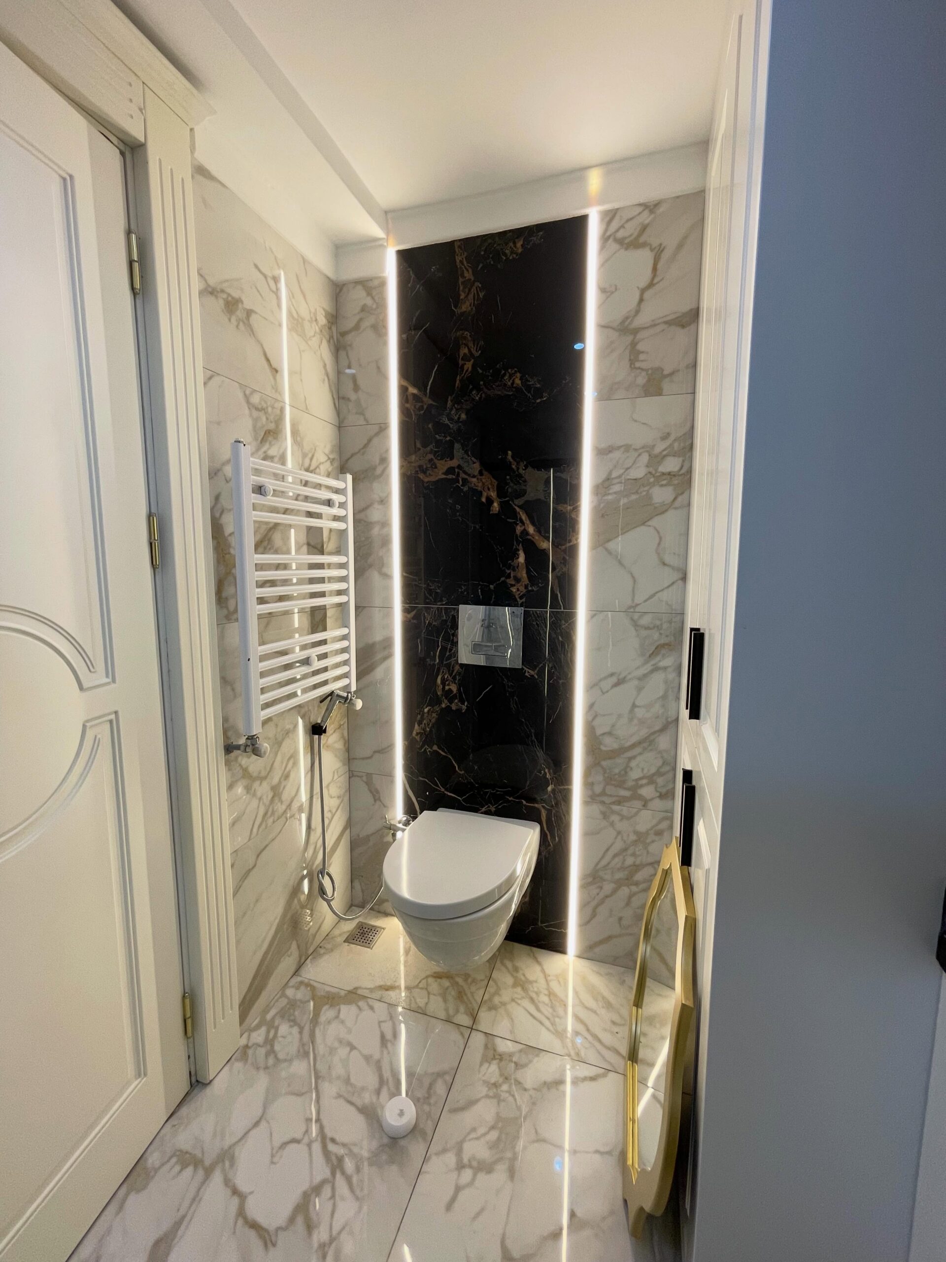 Mermer yüzey ve ışık detaylarıyla banyo uygulaması