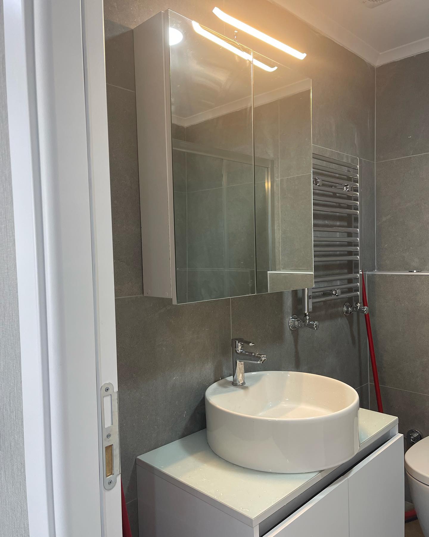 Gri taş kaplamalı lavabo ve ayna detayı